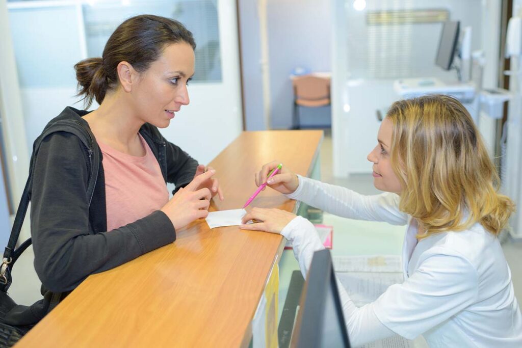 women speaking over front desk